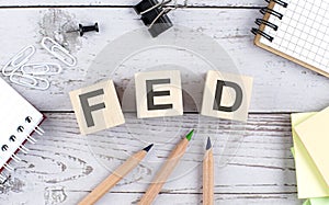 FED text on wooden block with office tools on the wooden background