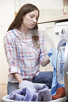 Fed Up Woman Doing Laundry At Home