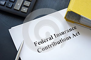 Federal Insurance Contributions Act FICA near yellow folder and calculator. photo