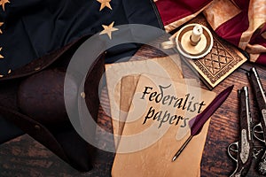 Federalist papers and the birth of the United States of America concept with tricorn hat, candle, feather quill, musket gun, the