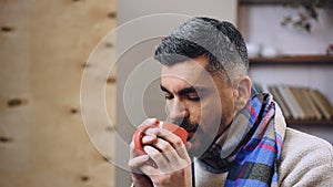 Feeble diseased male drinking hot tea with medicine to remove influenza symptoms