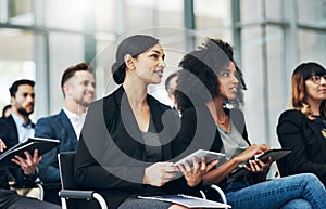 The feedback they are getting is great. a group of businesspeople sitting in the conference room during a seminar.