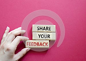 Feedback symbol. Concept word Share your feedback on wooden blocks. Businessman hand. Beautiful red background. Business and Ask