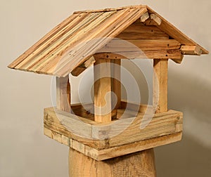 Feeder for birds. Wooden house with a roof.