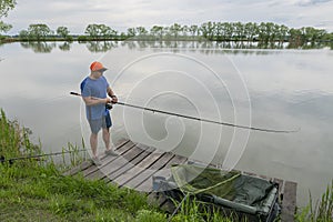 Feeder fishing. Fisherman in action, angler catch fish at lake pond