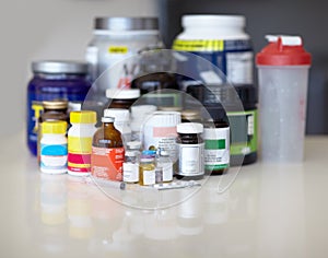 Feeding the addiction. Medicine bottles and pills with protein shakes and meal replacements.