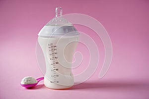 Feeding bottle of milk for baby with powder on color background
