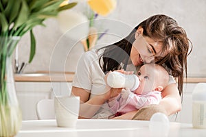 Feeding newborn girl with formula in a bottle.