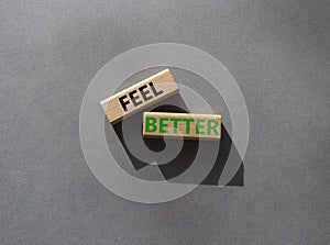 Feel better symbol. Wooden blocks with words Feel better. Beautiful grey background. Business and Feel better concept. Copy space
