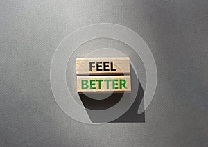 Feel better symbol. Wooden blocks with words Feel better. Beautiful grey background. Business and Feel better concept. Copy space