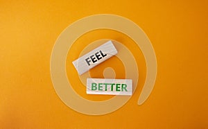 Feel better symbol. Wooden blocks with words Feel better. Beautiful orange background. Business and Feel better concept. Copy