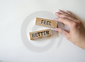 Feel better symbol. Wooden blocks with words Feel better. Businessman hand. Beautiful white background. Business and Feel better