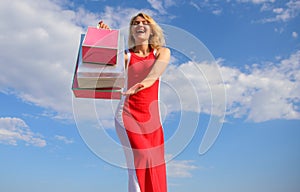 Feel free buy everything you want. Woman red dress carries bunch shopping bags blue sky background. Finally bought