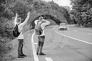 feel the freedom. Travelling with friends. Travel by autostop. Hopeless hitchhiker. Men try stop car. twins walking