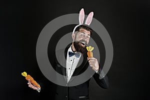 Feel the song. Easter singer. Businessman pretend singing with carrot. Bearded man sing song black background. Enjoying