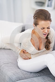 Feeling bad young woman sitting on sofa