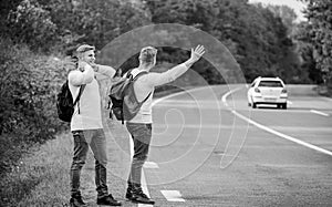 Feeling of being free. twins walking along road. stop car with thumb up gesture. hitchhiking and stopping car with