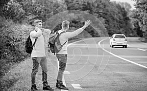 feeling of being free. twins walking along road. stop car with thumb up gesture. hitchhiking and stopping car with