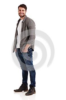 Feeling casual and confident. Full length studio shot of a smiling young man standing with his hands in his pockets.