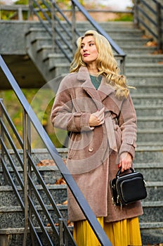 Feeling cold. sexy blong woman. autumn season. european winter. girl warm coat stairs background. faux fur coat fashion
