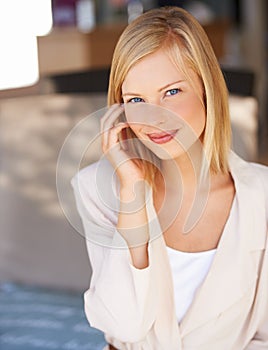 Feeling confident. Smiling young businesswoman tucking her hair behind her ear.