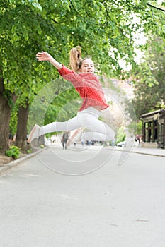 Feeling really energetic. Lively small girl jumping with energetic moves. Active kid being in energetic mood on summer