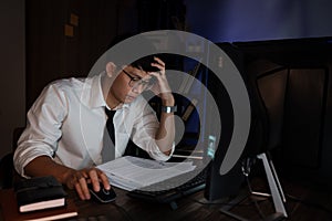 Feeling exhausted or Tired businessman working late on computer at office late in the evening night headache bad vision sight