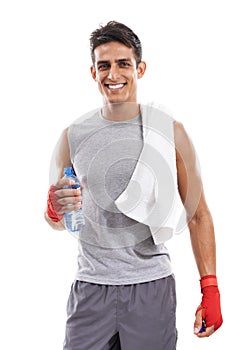 Feeling fantastic after a workout. Portrait of a smiling kick-boxer standing with a towel over his shoulder and a bottle