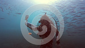 Feeling free among the fish. 4k video footage of an unrecognizable man scuba diving alone among the fish in the coral