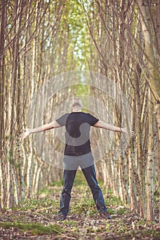 Feeling freedom, carefree and free raising his arms surrounded of nature, enjoying life