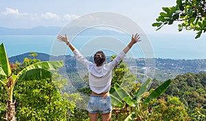 Feeling of freedom. Girl rising her hands up at the tropical viewpoint. Breathtaking view