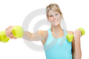 Feeling good about getting into shape. Sporty young woman lifting dumbbells while isolated on white.