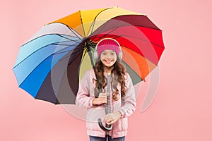 Feeling good. Girl having fun walking wireless headphones under colorful umbrella. Fall leisure. Music always with me