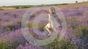 Feeling happiness little girl smile merrily flees jumping outdoors. beautiful landscape lavender field