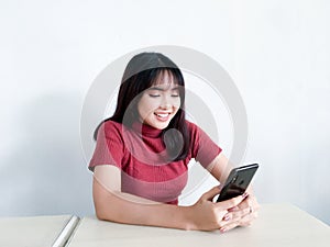 Feeling happy and smile face of Young beautiful asian woman looking on the smartphone. Indonesia women