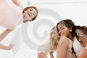 Feeling so happy. View from below of attractive young bride and two bridesmaids making faces while taking selfie in the
