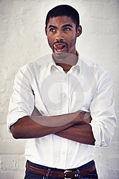 Feeling a little flakey. a young man with his arms crossed sticking out his tongue.