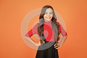 Feeling lucky. Perfect girl. Positive emotions. Teen girl smiling orange background. Teen child with long curly hair