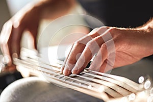 Feeling my instrument...Close-up of male hands touching metal strings of guitar