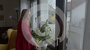 Feeling pensive young woman in red dress near window. Expressing pensiveness.