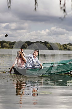 Feeling playful. Beautiful young couple enjoying romantic date while rowing a boat. Happy to have each other