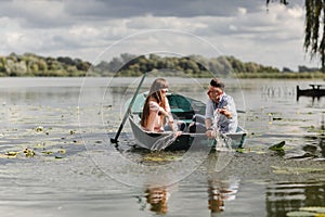 Feeling playful. Beautiful young couple enjoying romantic date while rowing a boat. Happy to have each other