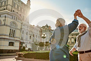 Feeling playful. Portrait of beautiful senior couple dancing together outdoors on a sunny day