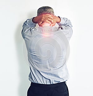 Feeling the strain of a stressful day. Studio shot of a mature man experiencing neck ache against a white background.