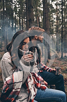 Feeling the warmness. Young beautiful couple enjoying hot drinks