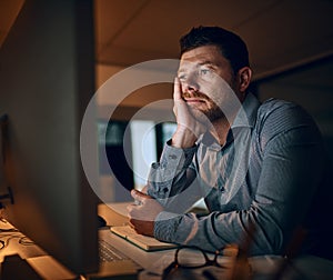 Feeling zero inspiration right now. a young businessman looking bored while working late in an office.