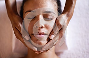 That feels divine. a young woman getting a head massage at a beauty spa.