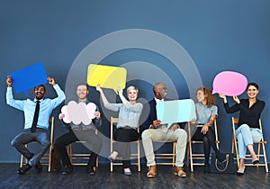 It feels good being able to speak your mind. Shot of a group of people holding up speech bubbles against a blue