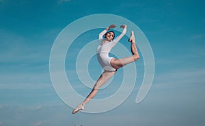 Feels like flying. Young ballerina jumping on blue sky. Pretty girl in dance wear. Cute ballet dancer. Concert
