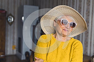 feels like summer. cute senior woman in hat and sunglasses at home medium closeup living room seniority concept